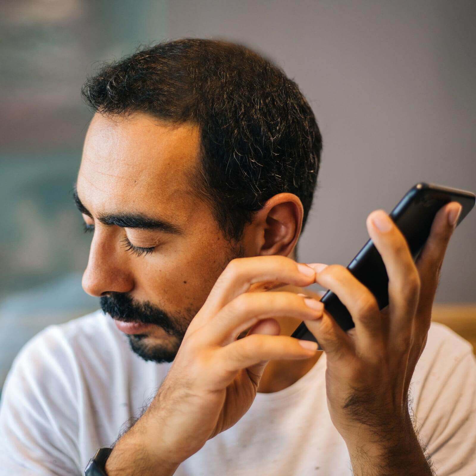 Blind man using mobile phone.